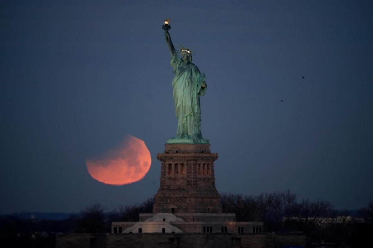 The Statue of Liberty is backdropped by a supermoon, Wednesday, Jan. 31, 2018, seen from the Brooklyn borough of New York.