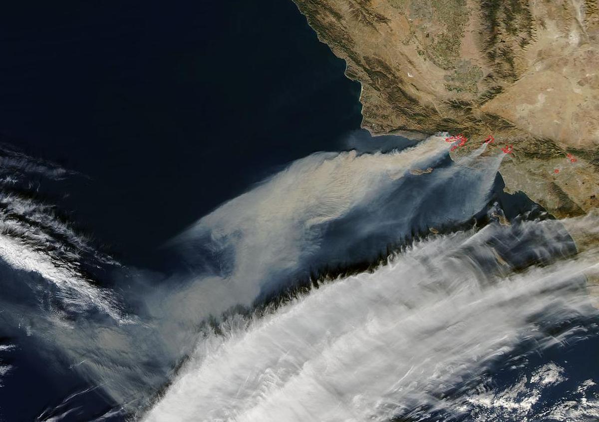 When the Santa Ana winds were blowing strong offshore, the plumes of smoke from the Southern California fires blew due west without spreading north, as seen in this photo from Dec. 6. Hot spots are shown in red. Now, the smoke is spreading all the way up the coast to the Oregon border.