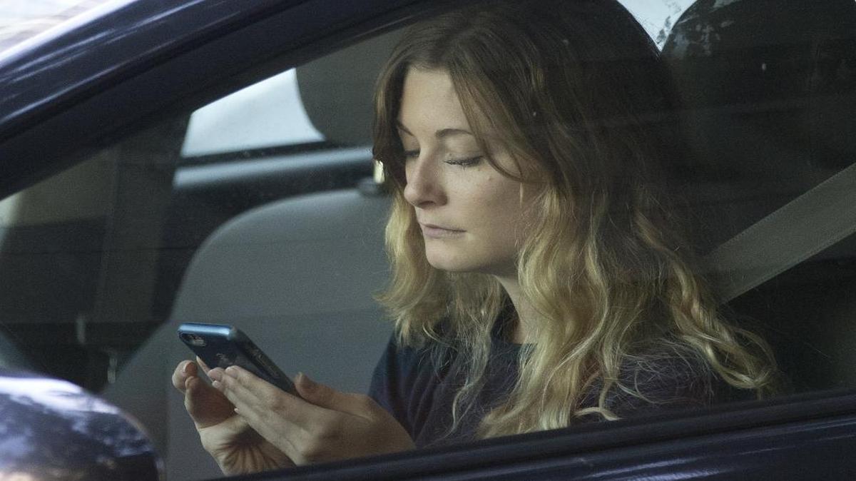 A driver uses her mobile phone while sitting in traffic in Sacramento on June 22, 2016.