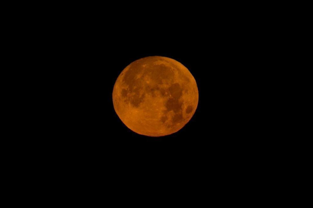 The moon sets in the Mediterranean sea off the coast of Hadera, Israel, early Wednesday, Jan. 31, 2018.