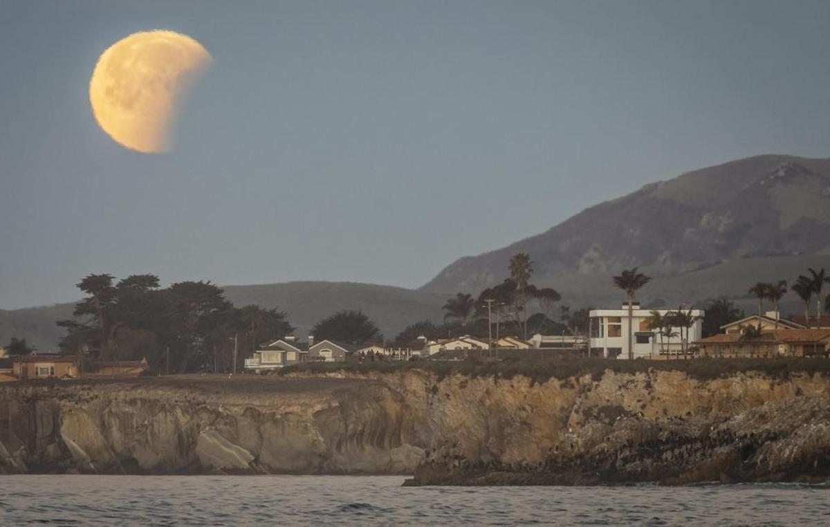 The super blue blood moon sets in partial eclipse over Shell Beach.