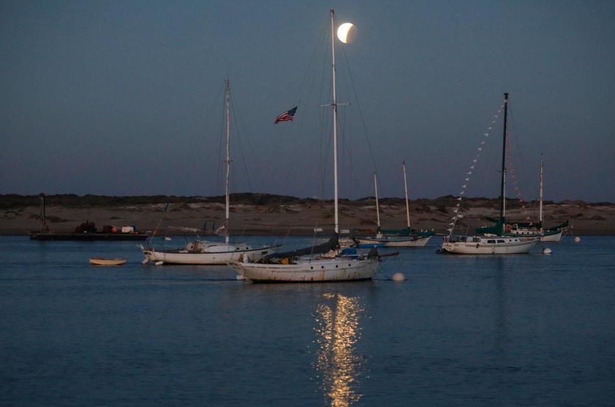 Blue blood supermoon comes out of the earth's shadow as it sets over Morro Bay.