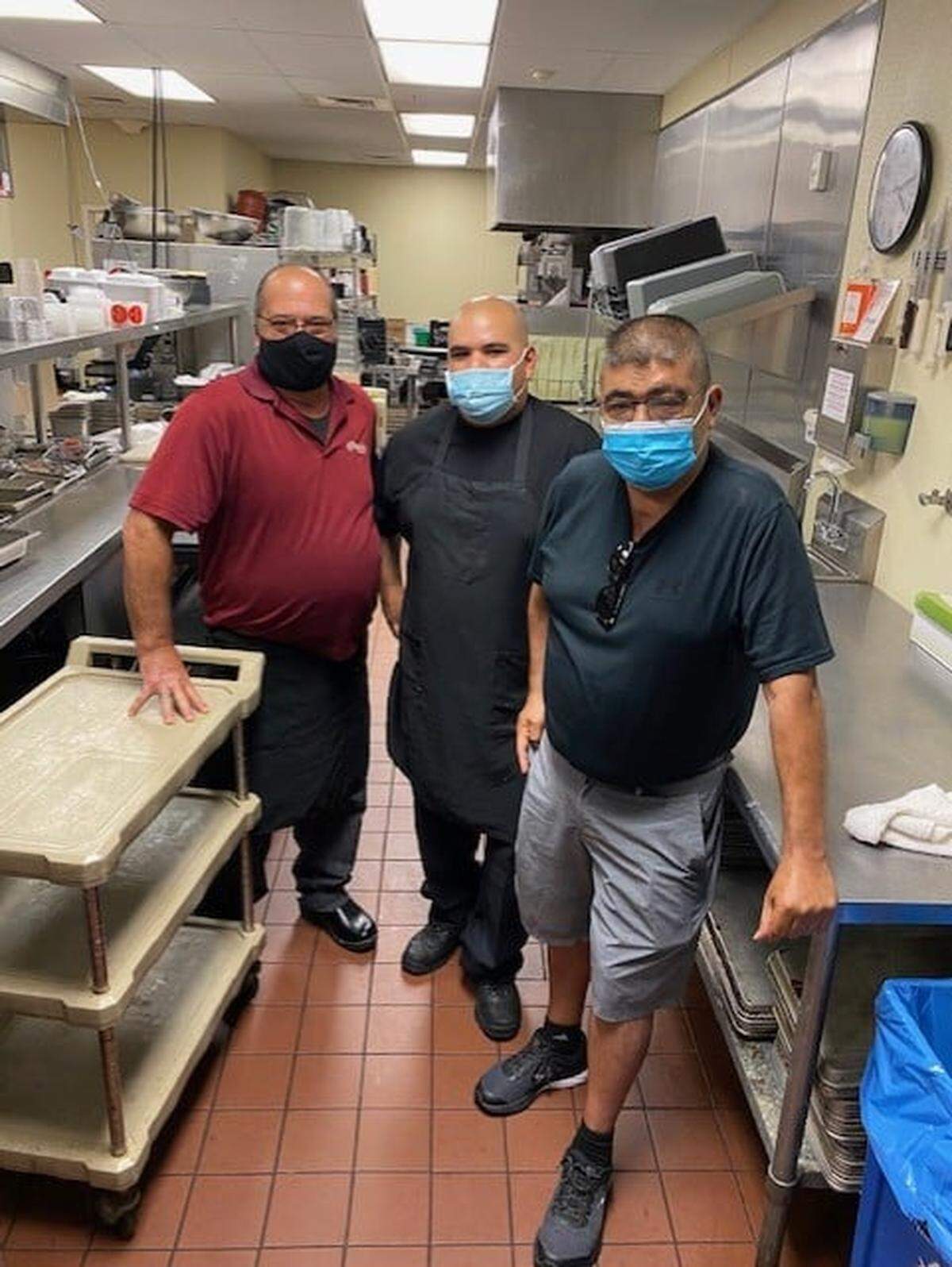 Leon Castillo, right, visits the kitchen at Courtyard by Marriott in San Luis Obispo, which partnered with Popolo Catering to provide takeout meals for hotel guests. Popolo Catering general manager Kenny Castillo, middle, and chef John Pastore, left, are also pictured.