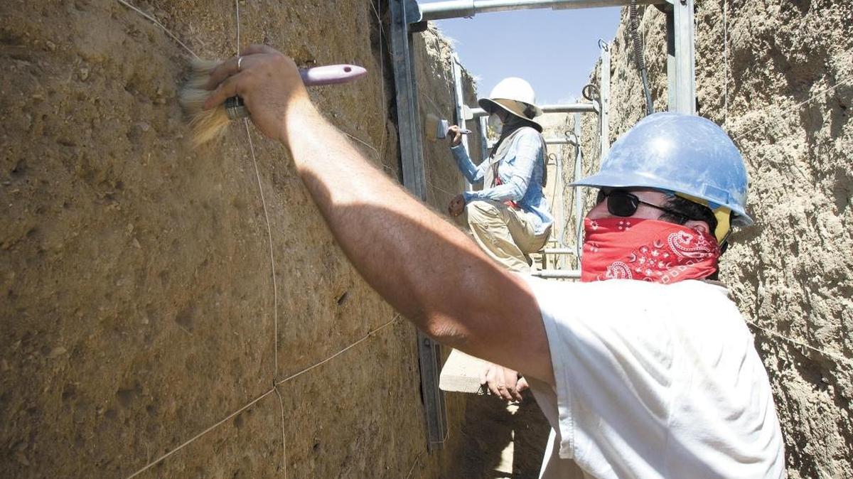 Workers wear masks to guard against the fungus causing valley fever. The fungus grows as microscopic spores in soil and the illness can be contracted by breathing in the spores.