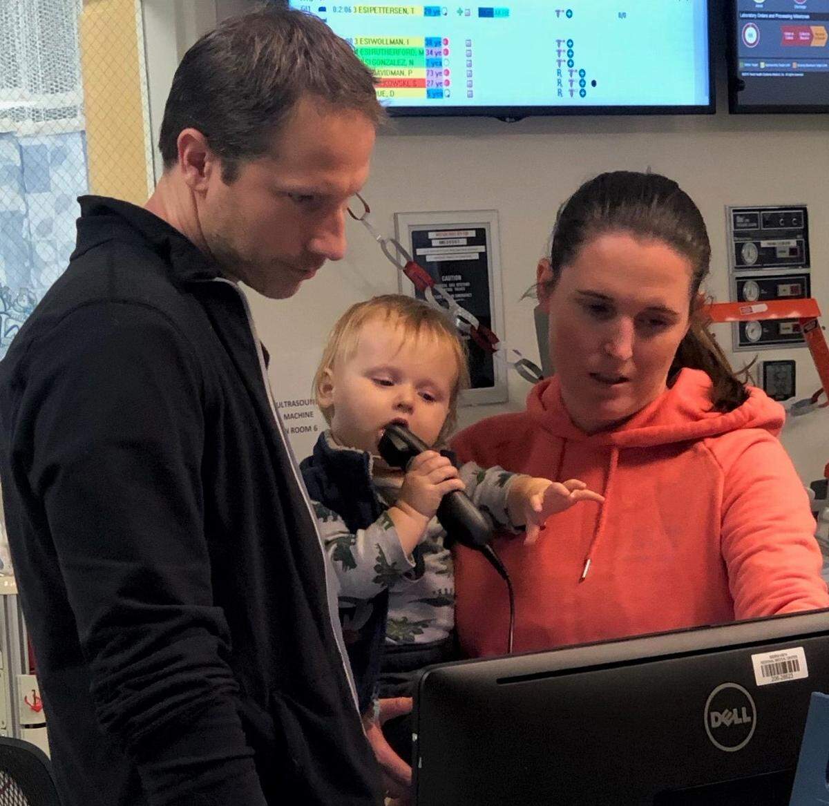 Tenet Health emergency room doctors Brad and Oma Knox with their son, Tully, 2, during a shift change.