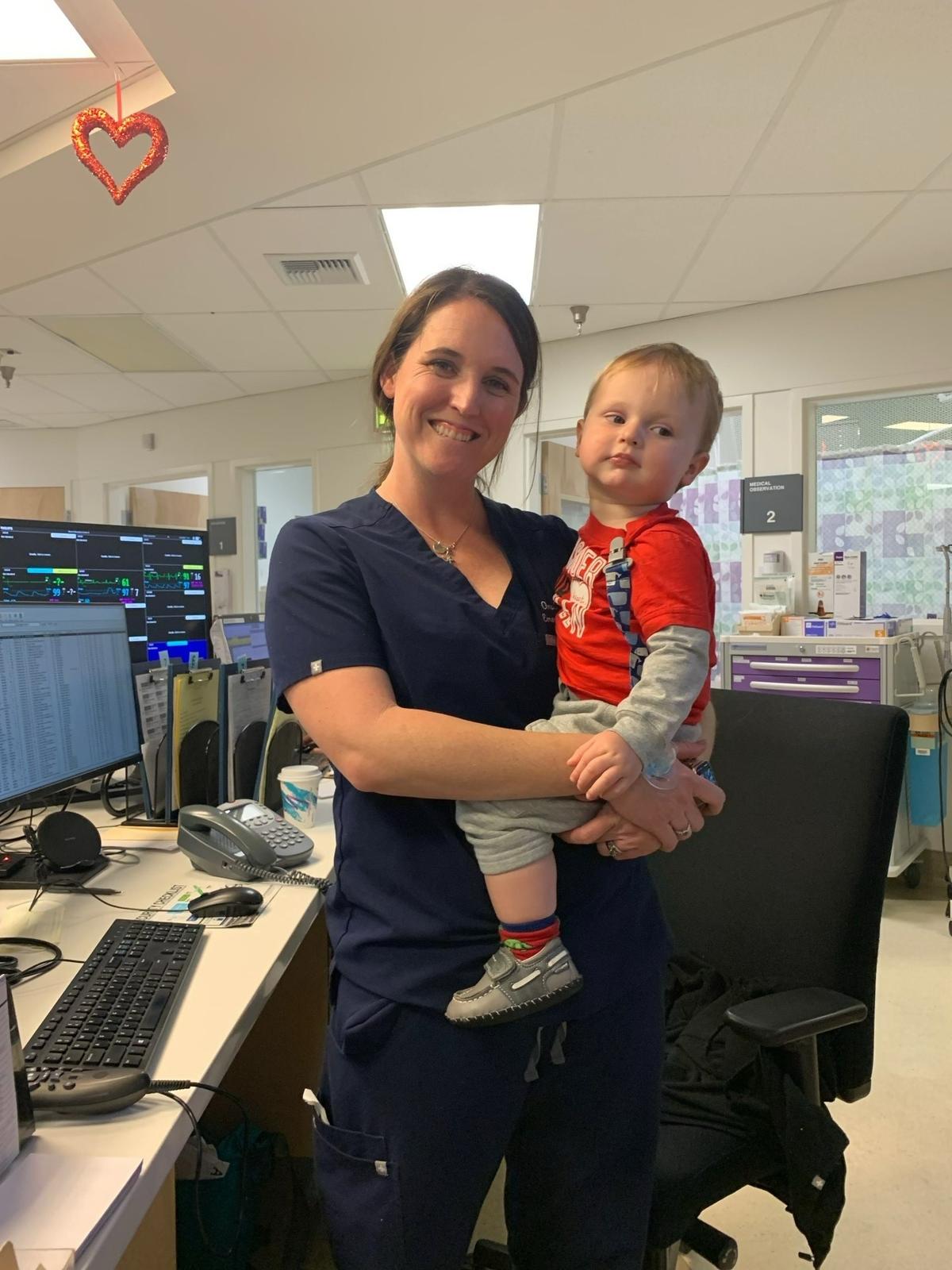 Dr. Oma Knox holds her son, Tully, age 2, during a shift change before the COVID-19 pandemic.