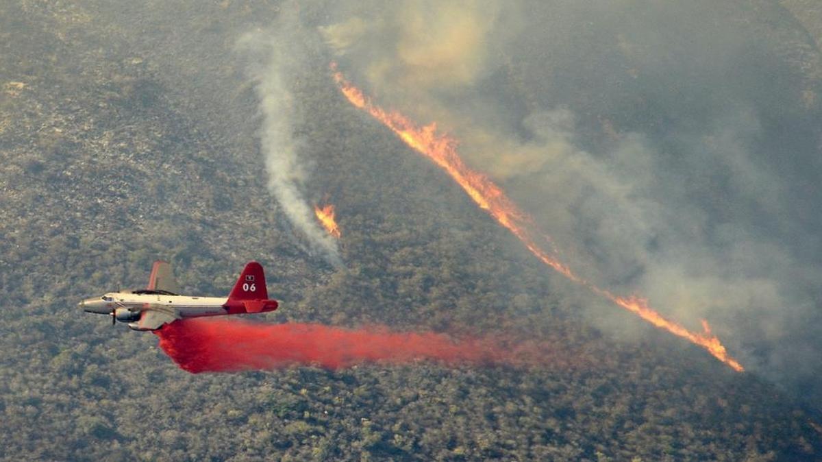 A P-2 Neptune aircraft drops retardant on the Canyon Fire burning at Vandenberg Air Force Base in Santa Barbara County on Sunday.
