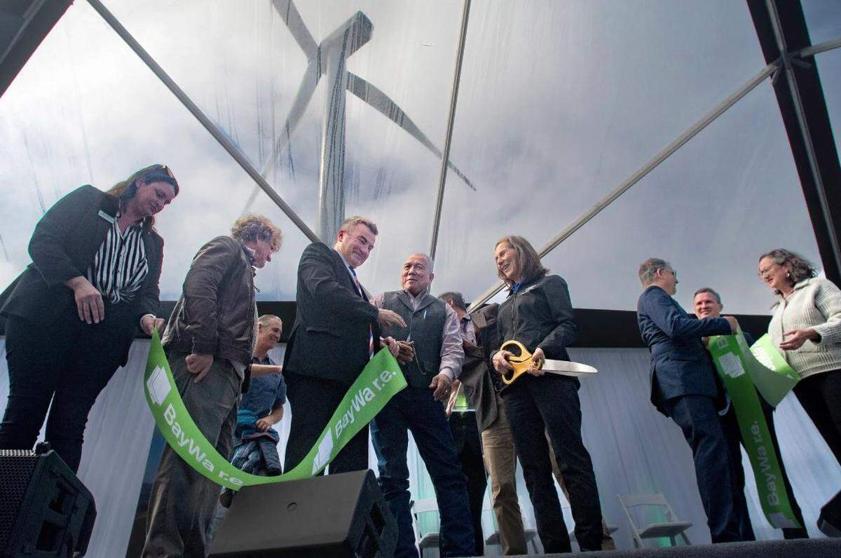 Gordan McDougall, center, CEO of BayWa r.e. Wind LLC, celebrates the official opening Thursday of the Strauss wind farm near Lompoc with other officials, including Santa Barbara County Supervisor Joan Hartmann, holding scissors, inside a reception tent underneath a wind turbine.