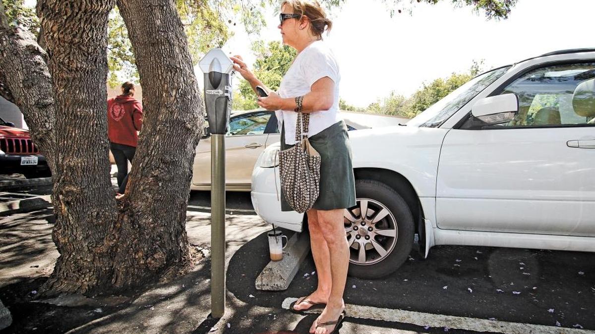 Elizabeth Tymn of Shell Beach pays for parking with a credit card at a downtown San Luis Obispo meter, in this 2015 photo.