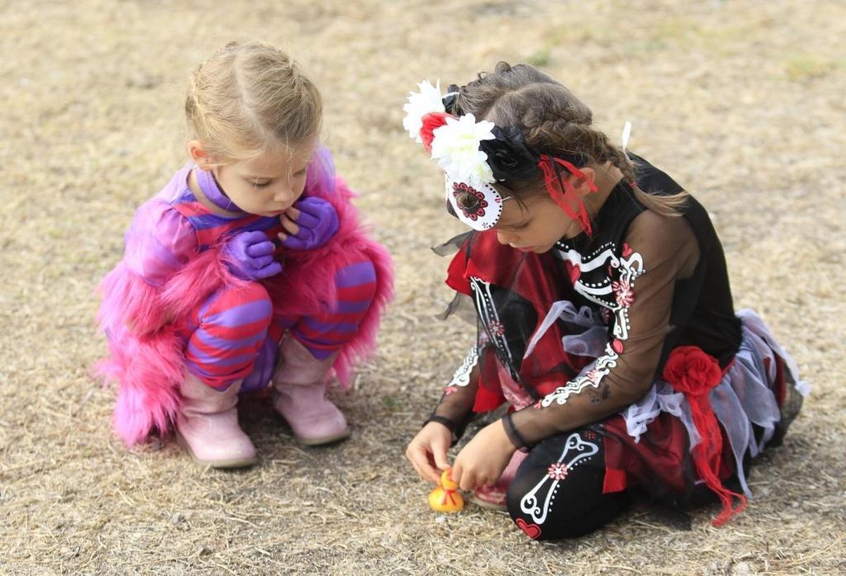 Savannah Torres, 3, and sister Charlize, 4, of Pismo Beach, play with small toys in their costumes Saturday at Pumpkins in the Park in 2017.
