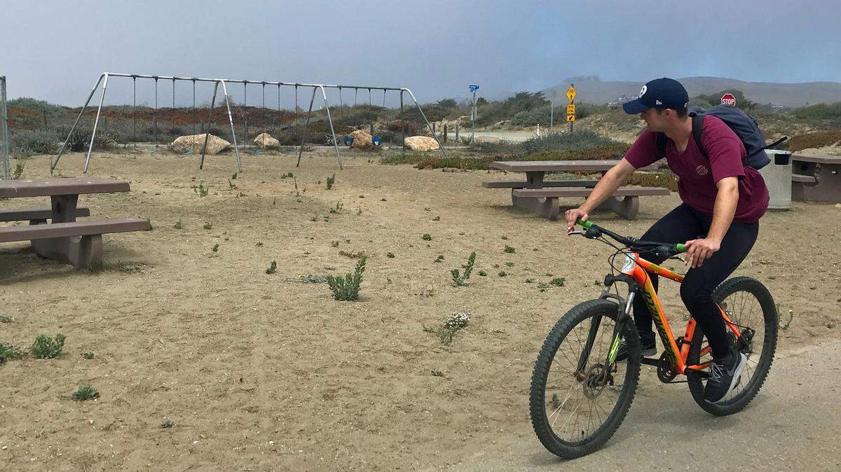 A cyclist pedaling along Morro Bay’s bayfront bicycle path checks out Coleman Park near Morro Rock. California State Parks approved a $600,000 grant on Monday, Aug. 22, 2022, to add amenities to the park.