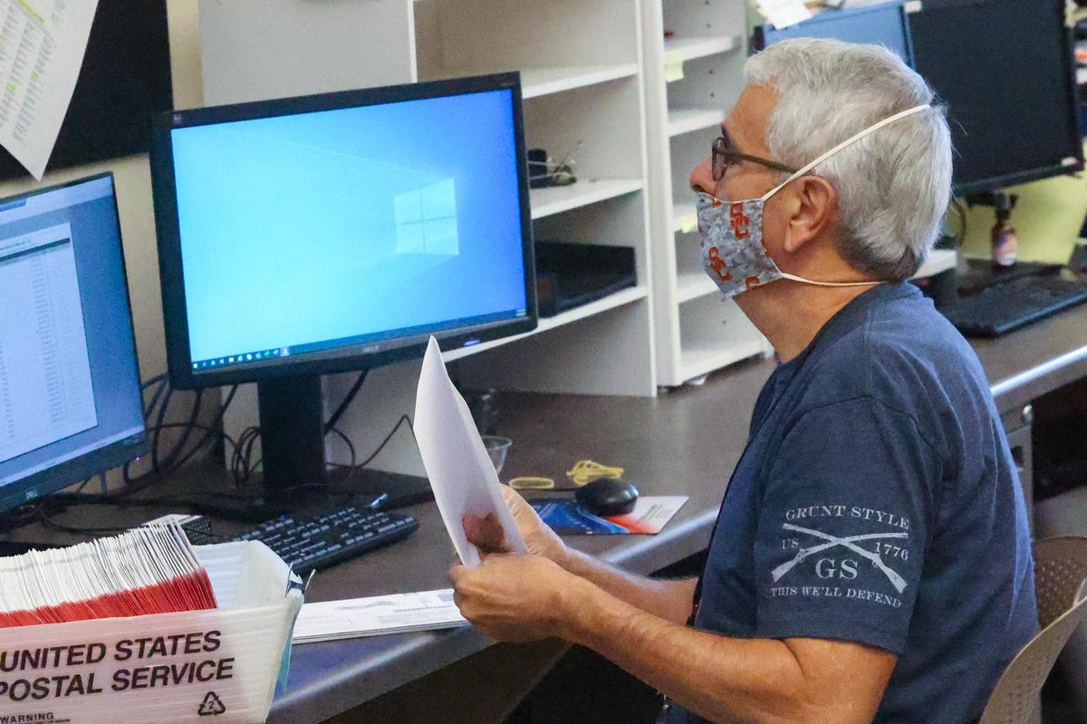 Jim Jeffrey, a temporary San Luis Obispo County elections employee, conducts signature checks on mail-in ballot envelopes. Sept. 14, 2021, was Election Day in the recall race that will decide whether Gov. Gavin Newsom will remain in office or be replaced by another candidate.