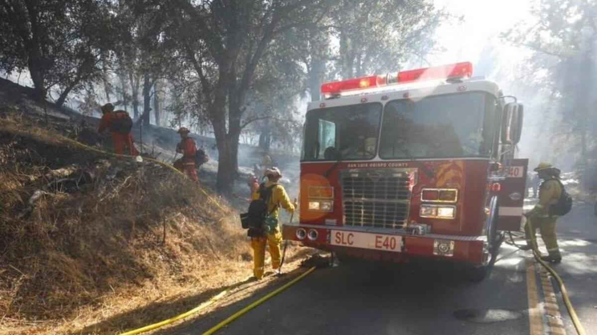 Firefighters fight a brush fire off Pozo Road on Monday, Oct. 9, 2017. The fire is now nearly contained.