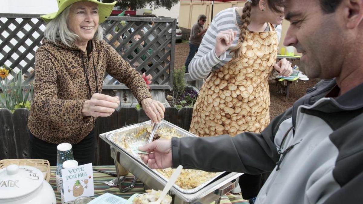 Laurel Leopold serves Colcannon casserole to Nathan Griffin at Tater Day on Traffic Way in Atascadero on Saturday. The dish was prepared by Fig Good Food and included potato, cabbage, green onion, apple, fennel and roasted leg of lamb.