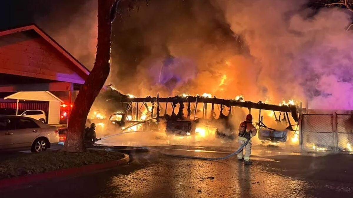Firefighters battle a suspected arson fire at two carports at an apartment complex on West Morrison Avenue near Blosser Road in Santa Maria early Thursday, May 29, 2025. As many as 20 vehicles were damaged or destroyed in the blaze.