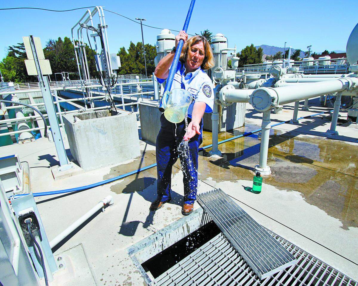 San Luis Obispo wastewater plant chief operator Pam Ouellette pulls out a sample of treated wastewater that is on its way to the San Luis Creek.