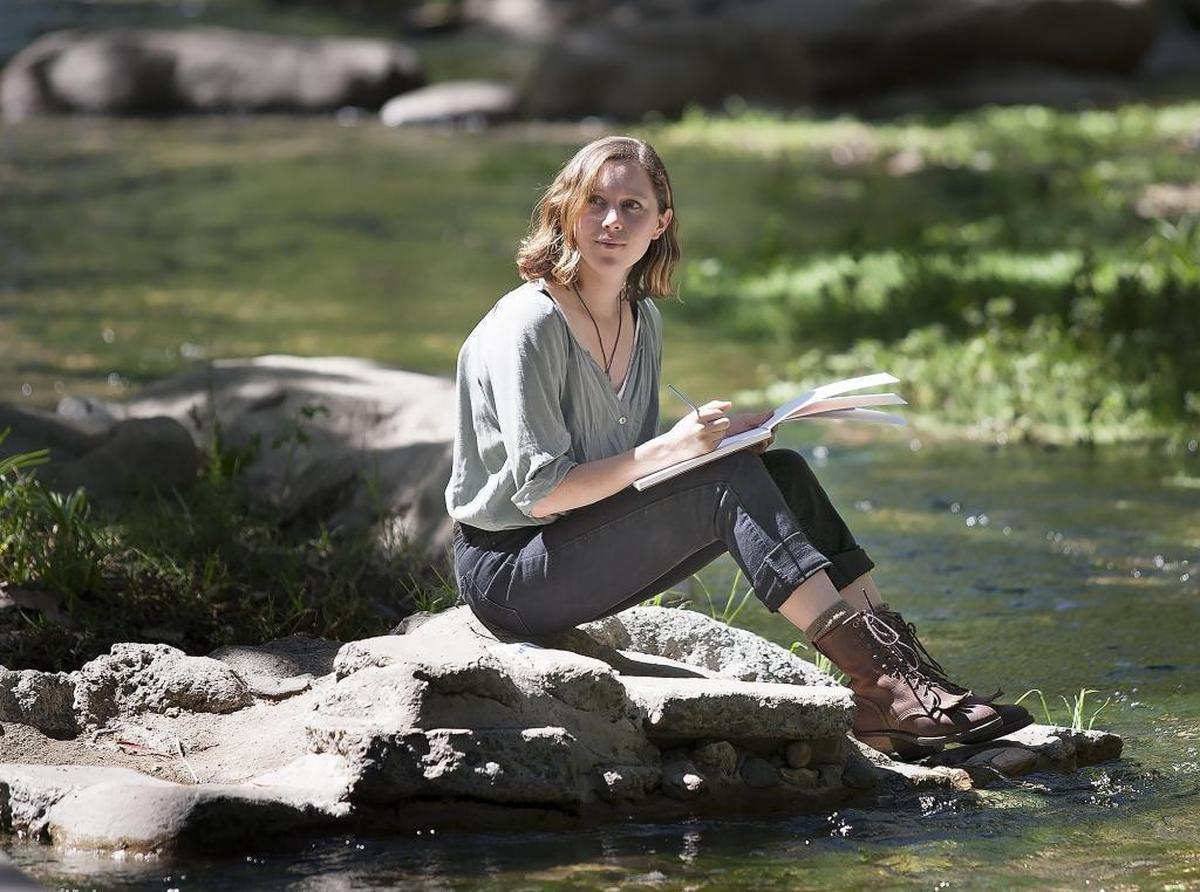 Jordan Chestnut of San Luis Obispo sketches while sitting beside San Luis Obispo Creek.