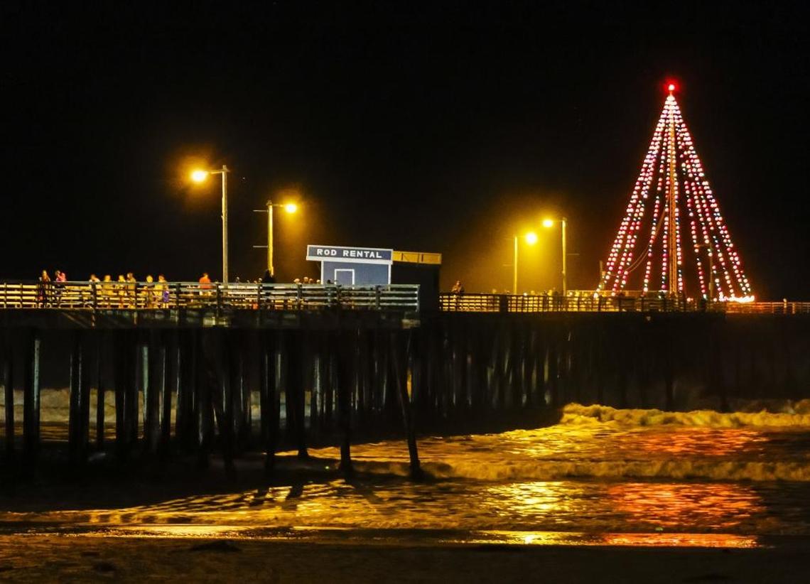 The tree at the end of the Pismo Beach Pier glows in the night shortly after being turned on during the Holiday Harmony & Tree Lighting Ceremony Friday evening.