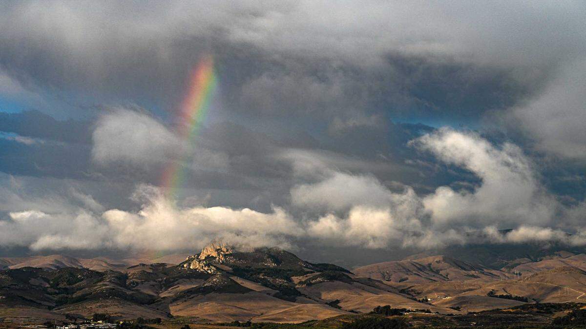 A rainbow peaks out of the clouds gathering over Hollister Peak near Los Osos.