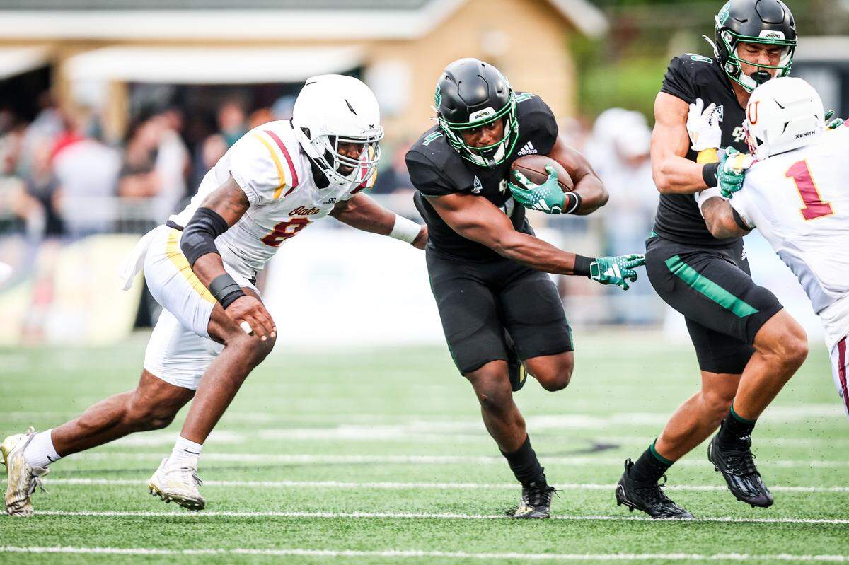 Cal Poly Mustangs running back Mark Biggins (4) rushes the ball up the middle. The Cal Poly football team beat Lincoln 41-20 at home on Sept. 16, 2023. 