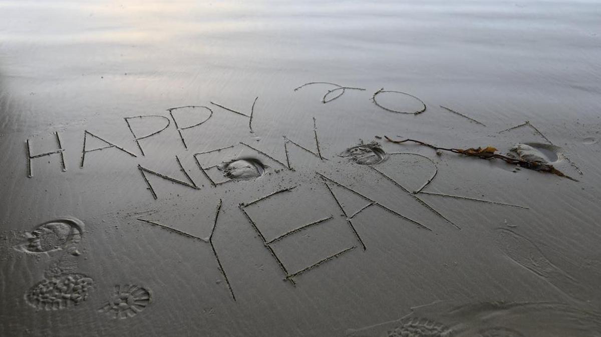 Someone used a piece of seaweed to write “Happy New Year 2017” in the wet sand at Oceano Dunes State Vehicular Recreation Area against a lovely late-afternoon sunset on Dec. 31, 2016.