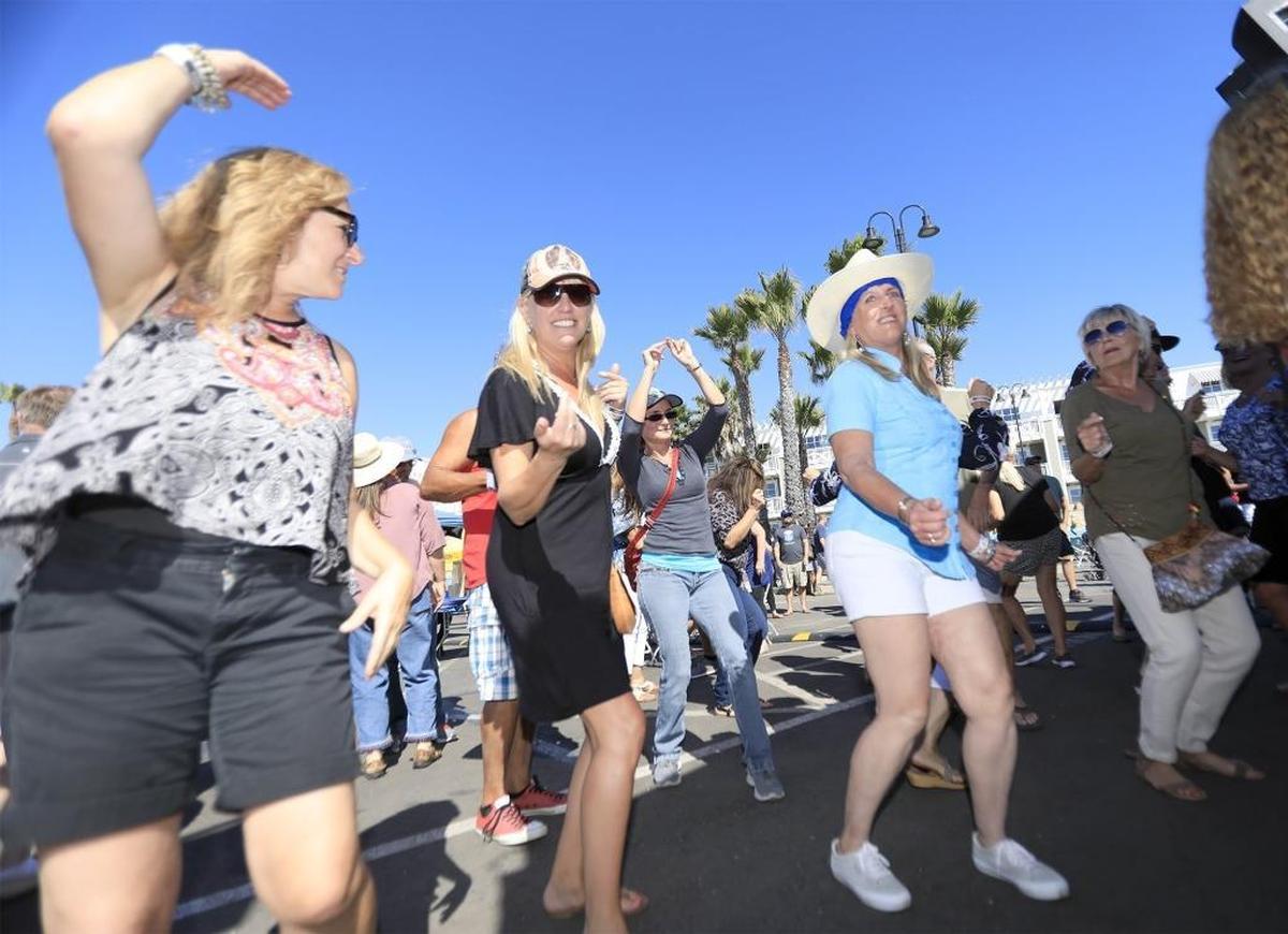 Dancing to ’80s music from The Molly Ringwald Project rock band are (from left) Marci Mora of Grover Beach, Cyndy Absmeier of Shell Beach, and Julie Walters of Los Osos. The women were celebrating Absmeier’s 50th birthday during the Pismo Beach Clam Festival.