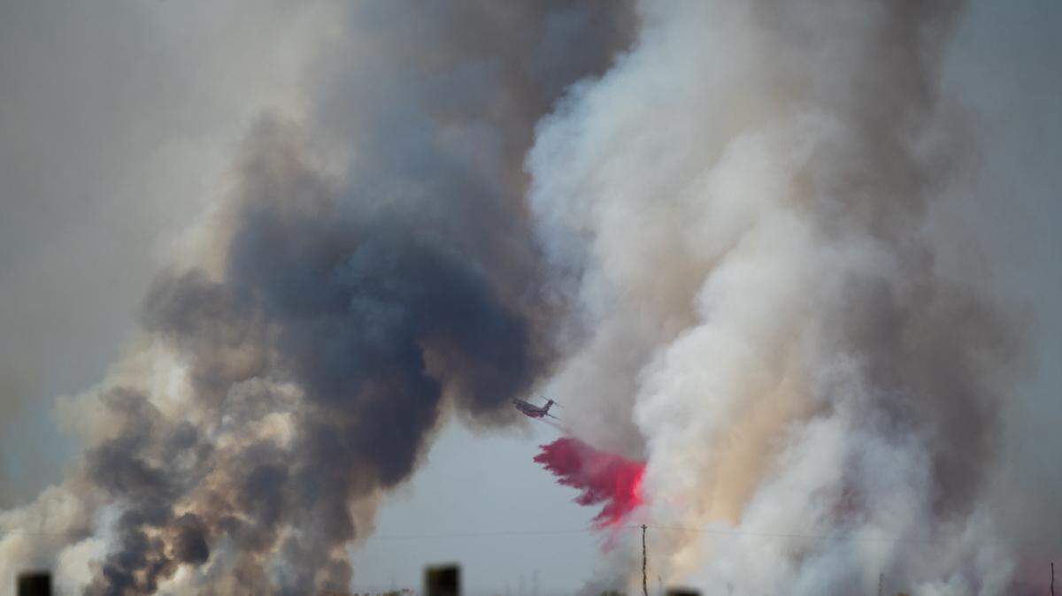 A Cal Fire plane drops retardant on a fire that burned 500 acres in California Valley on Monday, Sept. 30, 2024.