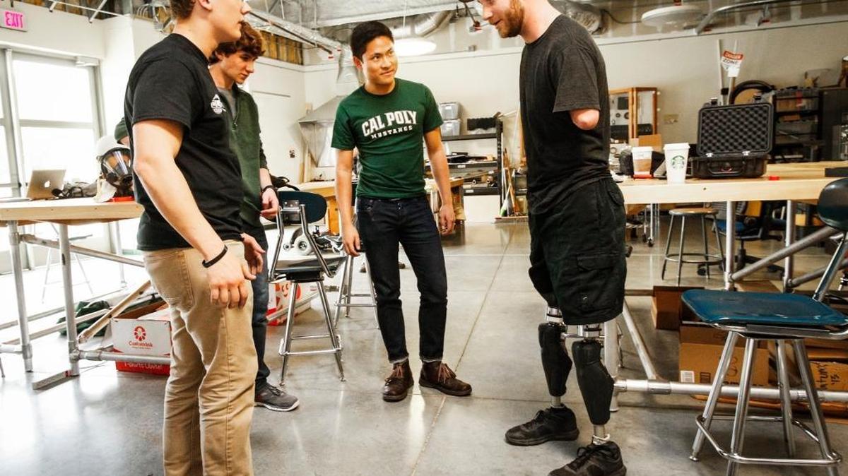 Cal Poly students Greg Orekhov, left, Zachary Hanze, Andre Arguelles look on as Army veteran Taylor Morris tries out their quick connect system for his prosthetics legs at the Quality of Life Plus program.