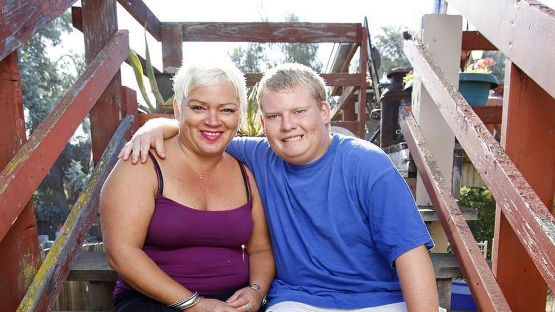 Tyler Jarvis, who has Prader-Willi syndrome, sits with his mom, Michelle Christian, at their Pismo Beach home.