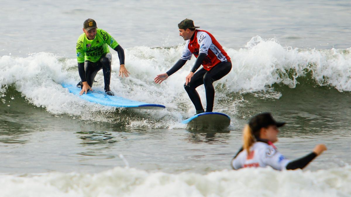 Richard Brendle, left, and Lance Iunker, who served together in Iraq, ride a wave together in Avila Beach during Operation Surf, a week-long program for wounded-veterans and active-duty military.