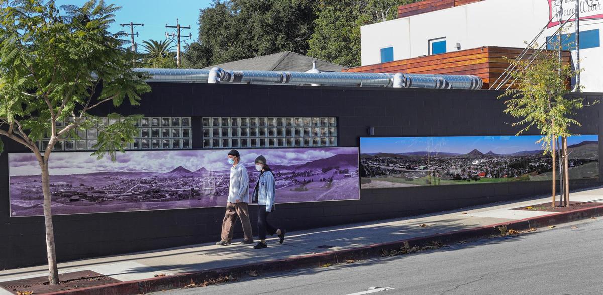 Two murals of San Luis Obispo are on the corner of Johnson and Monterey Streets, Jan., 4, 2022. Frank Aston made the black and white photo in 1930 showing steam engines and hay being harvested. Brian Lawler made the new digital image by stitching together 1,694 images and using a 60-foot lift to recreate the viewpoint that was mined away in the 1940s to build freeway.