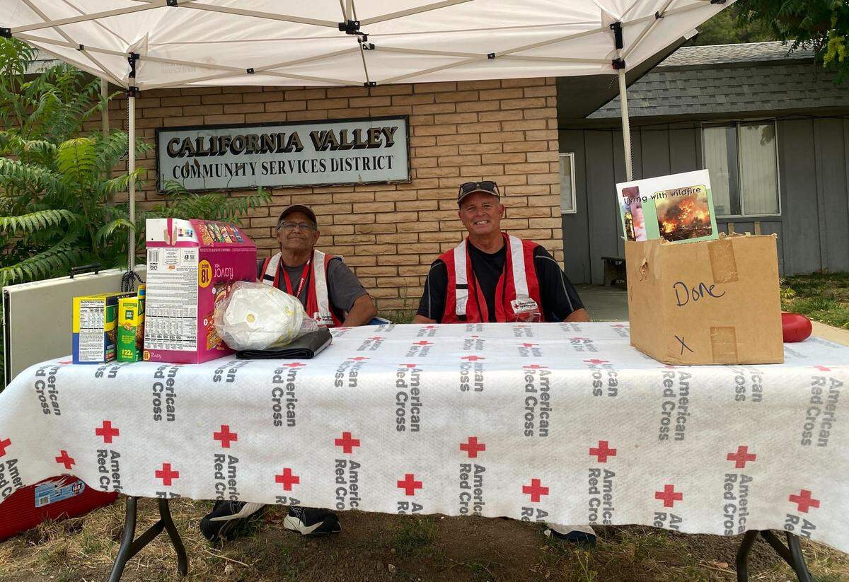 Volunteers Clay Phipps, left, and Jude Fledderman wait to pass out snacks and water to volunteers at the evacuation center for the Madre Fire burning in San Luis Obispo County.