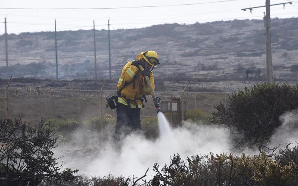 A firefighter sprays down a hot spot while battling the 12,000-acre Canyon Fire burning on Vandenberg Air Force Base.