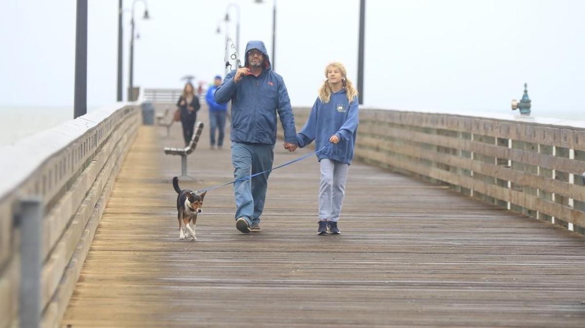 Walking on the Cayucos Pier in a light rain is Hazel Wijsen, 10, her dad, Mark, and dog, Milky Way. They did a little fishing Sunday afternoon.