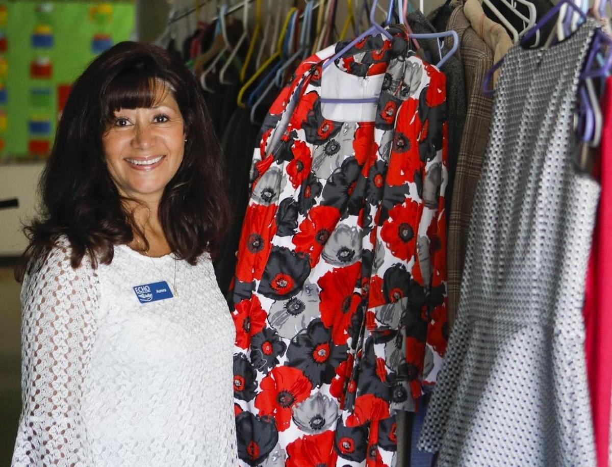 Aurora William, executive director of ECHO in 2017, stands near a rack of clothing that will help homeless clients upgrade their wardrobe for job interviews.