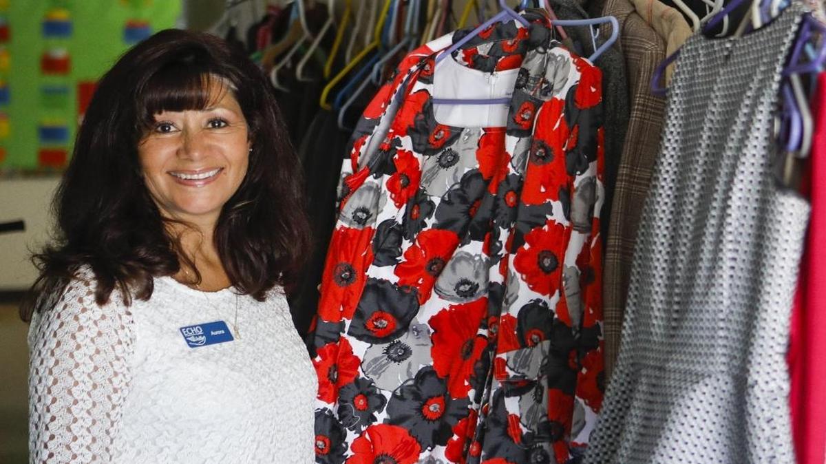 Aurora William, executive director of ECHO in 2017, stands near a rack of clothing that will help homeless clients upgrade their wardrobe for job interviews.
