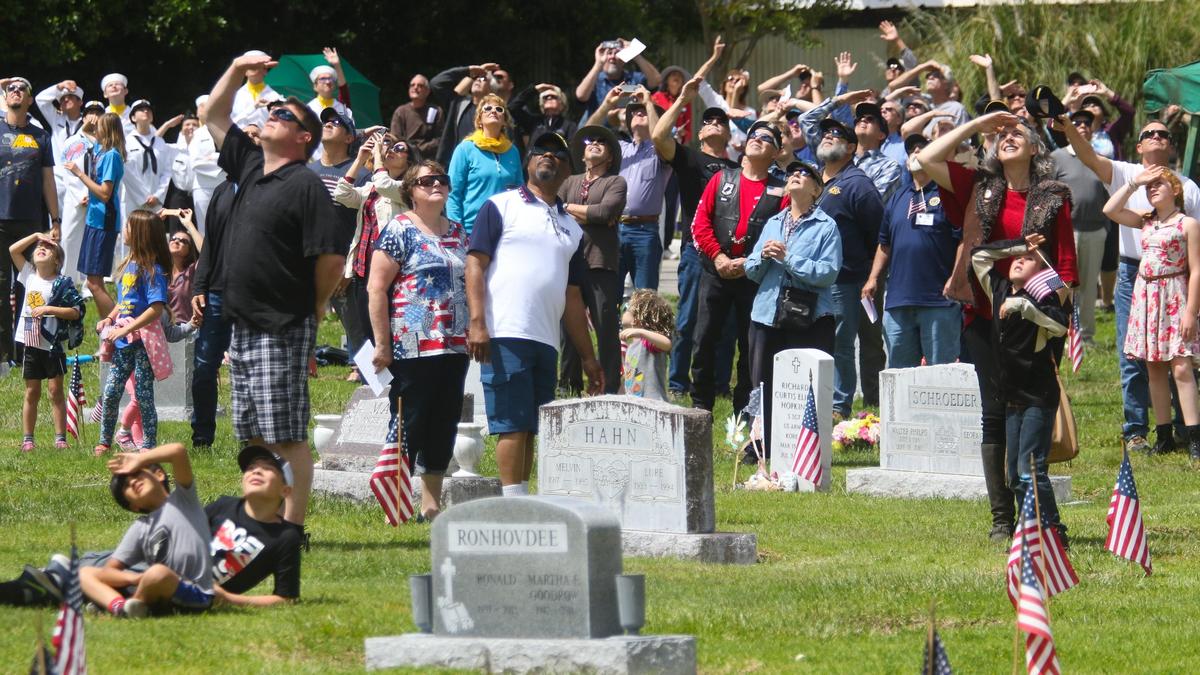 People attending a Memorial Day ceremony in 2019 at San Luis Cemetery Mausoleum and Memorial Gardens in San Luis Obispo take a break to watch military aircraft perform a flyover. Local Memorial Day ceremonies look different in 2020 due to the coronavirus pandemic.