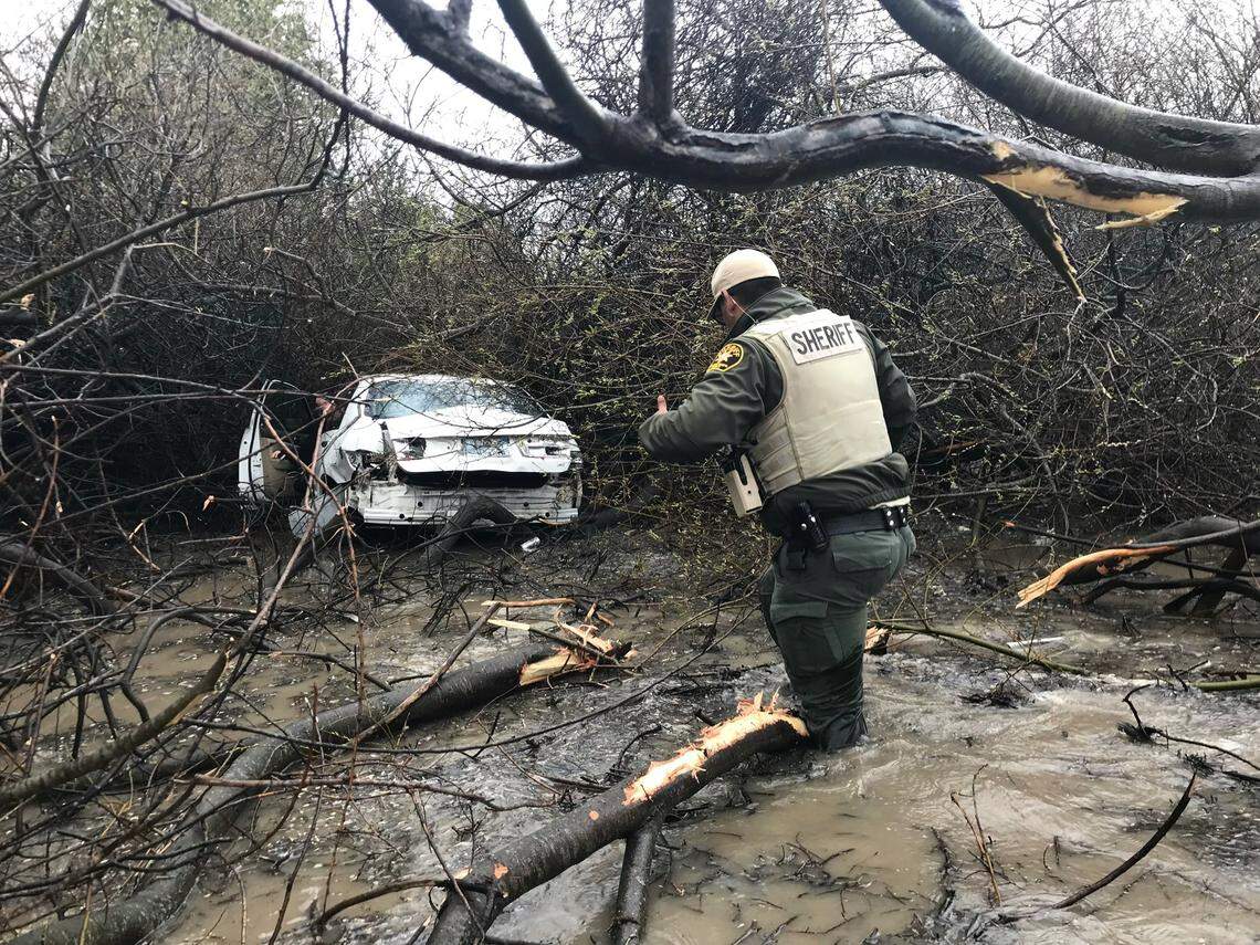 A San Luis Obispo County Sheriff’s Office deputy helps the driver of a vehicle that spun out on Highway 101 and landed in a water-and-brush-filled ditch near the Higuera Street off-ramp. 
