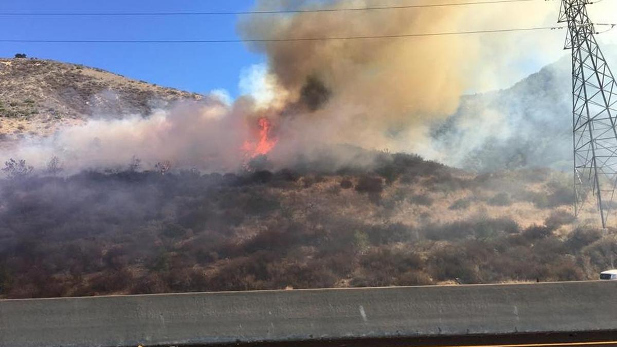 A burning car ignited nearby brush on the Cuesta Grade on Tuesday, Oct. 20.