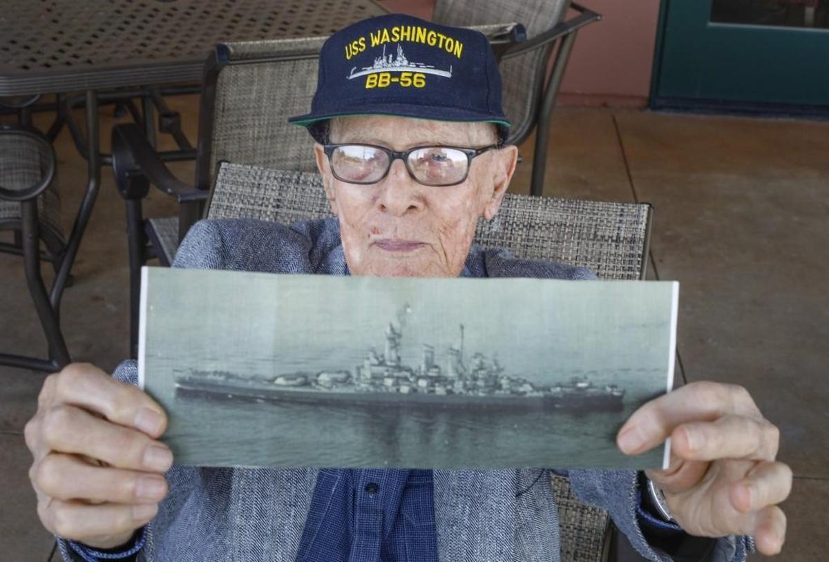 Thomas Coryell shows a photo of the USS Washington, the battleship he served on in the Pacific Theater during World War II. Coryell attended a luncheon Thursday honoring WWII veterans and other service members at the San Luis Obispo Country Club.
