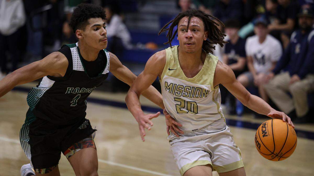 Jayden Nozil dribbles around Bryant Bell. Mission Prep overcame a first half deficit to finish with a win over Hoover of Fresno, 67-56 in a high school basketball playoff Feb. 20, 2024.