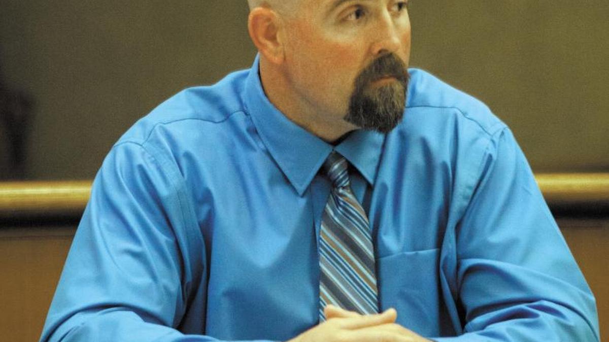 Prison guard Travis Woolf listens to witness testimony in court on Nov. 14, 2014.