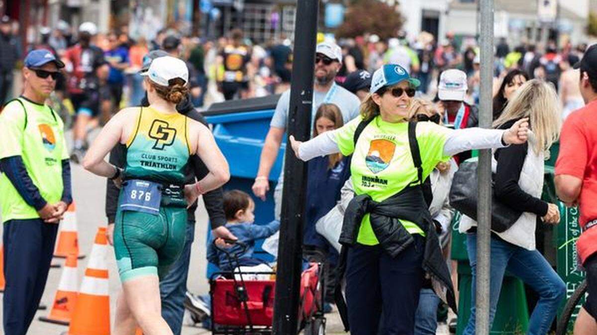 A volunteer directs traffic during the Ironman Triathlon in Morro Bay in 2023.