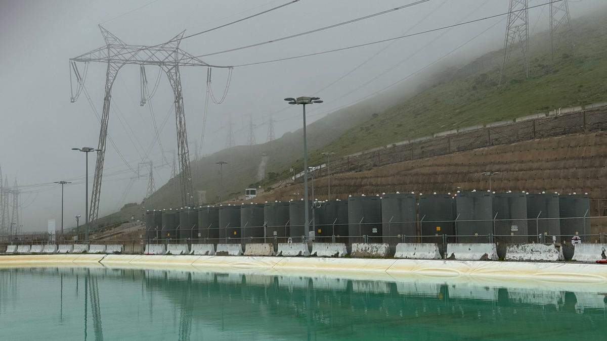Power lines run above the dry cask storage facility, which holds spent fuel from Diablo Canyon nuclear power plant. In the foreground is the plant’s fresh-water reservoir.