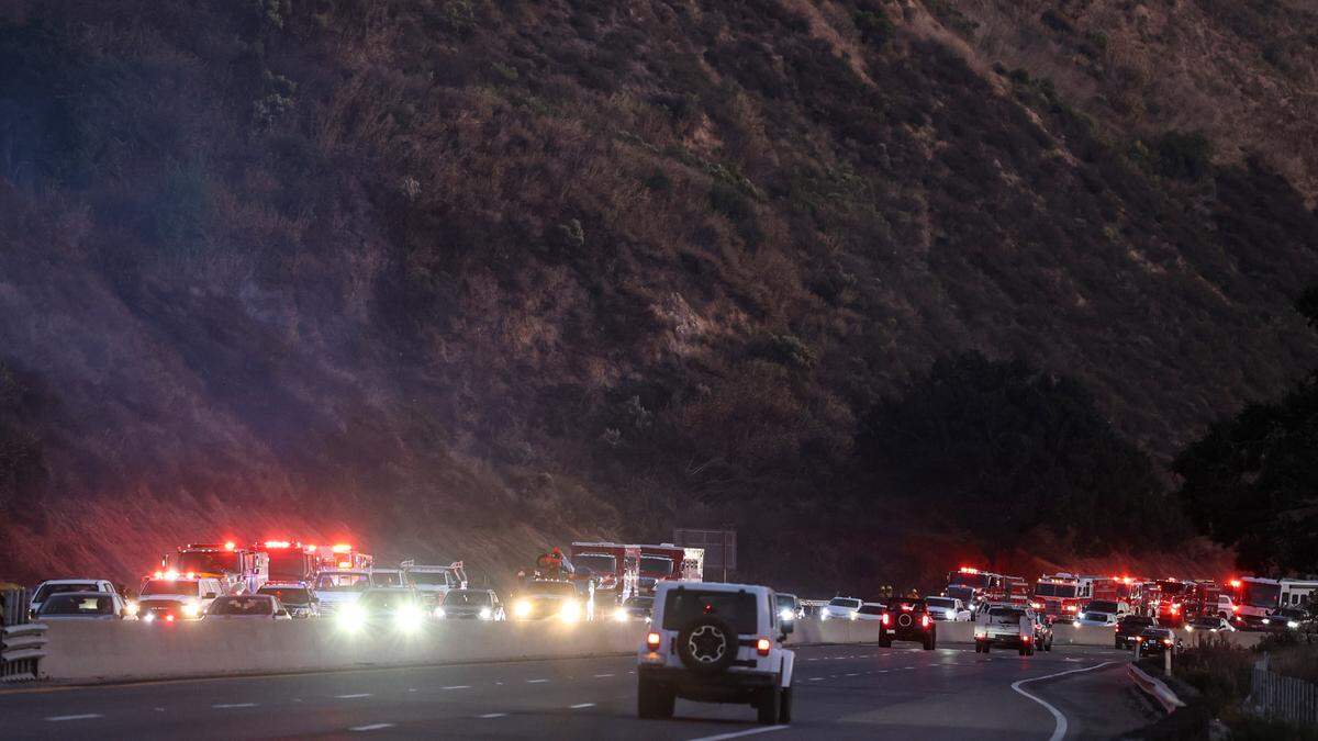 Firefighters worked along the northbound summit of Cuesta Grade on Highway 101 on Nov. 10, 2023, after a brush fire burned up the hillside. Traffic backed up to San Luis Obispo as the slow lane was closed to give room to work.