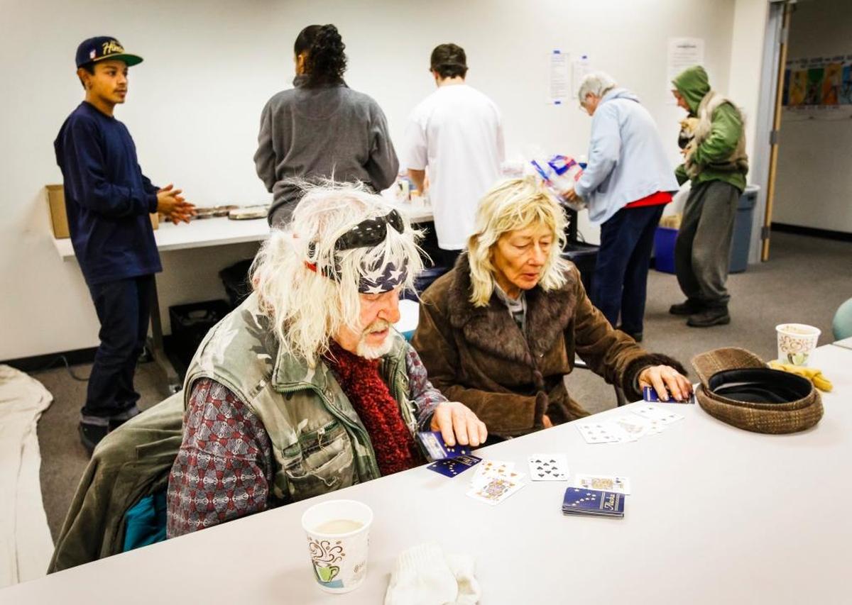 Jon Akeman and Linda McClelland play cards at the 5 Cities Homeless Coalition Warming Center at the department of Social Services in Arroyo Grande in January.