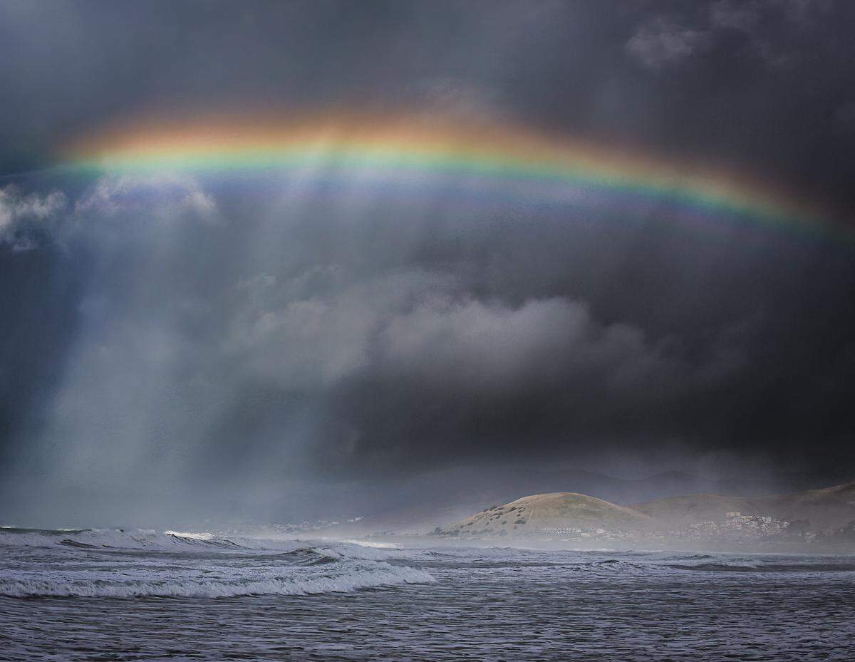 A rainbow arches over Morro Bay during a break in the clouds on Saturday, Dec. 30, 2023.