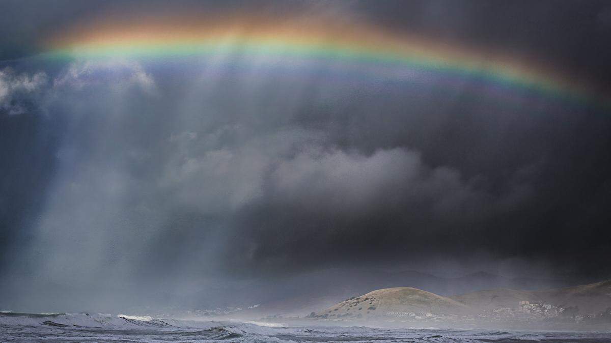 A rainbow arches over Morro Bay during a break in the clouds on Saturday, Dec. 30, 2023.