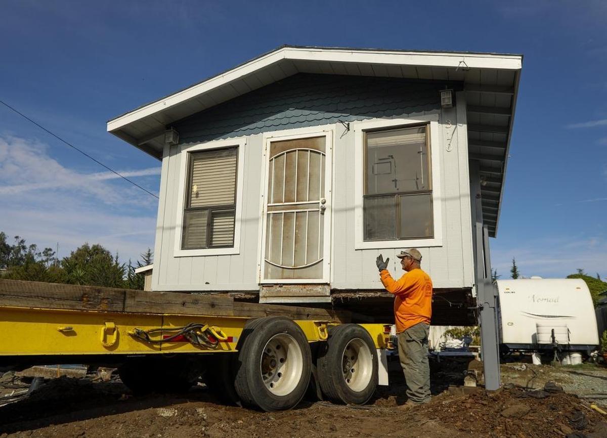 Scott James and his wife Gayle donated their Cayucos beach home to a woman who moved it across town on Monday with the help of Brandt House and Building Movers. Here, workers back a trailer under the home.