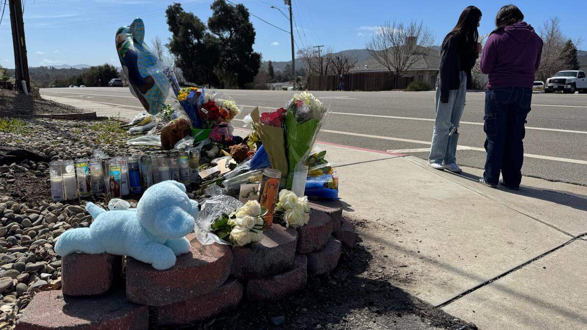 Mourners visit a makeshift memorial on Saturday, March 15, 2025, for an 11-year-old Atascadero boy who was killed the day before in a hit-and-run near the Danish Care Center on El Camino Real. A gray pickup truck hit the boy on the sidewalk and then drove off.